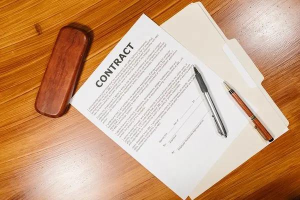 paper contract on a folder on top of of a desk