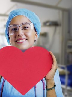 featured nurse holding red heart shape at a hospital room