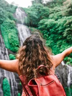 featured travel nurse exploring nature outdoors looking at waterfall