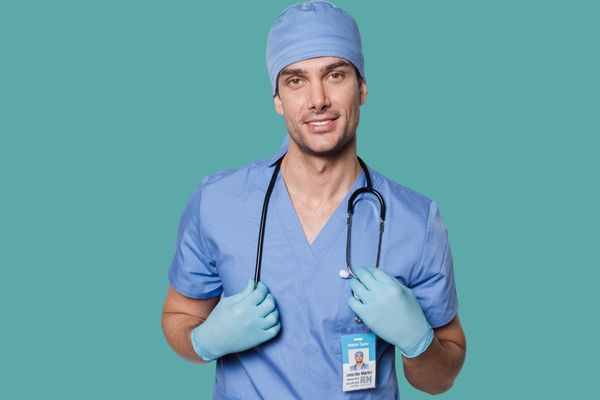 male nurse in blue scrubs with stethoscope and RN name badge
