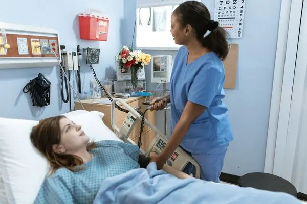 nurse caring for lady laying on hospital bed 