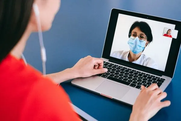 nurse talking to patient on computer screen