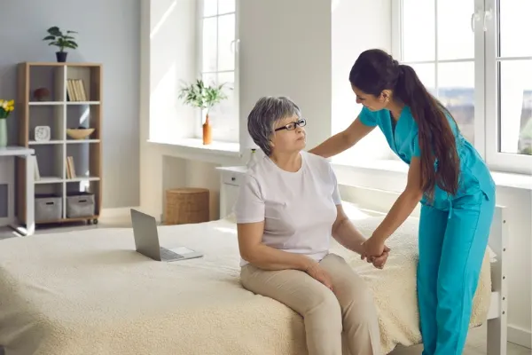 A nurse communicating with a elderly woman and assisting her
