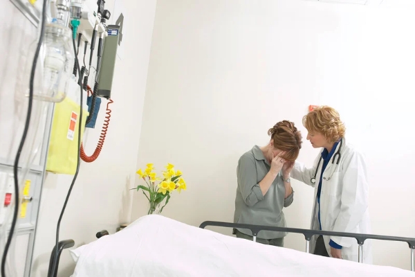 A nurse condoling with a loved of the deceased