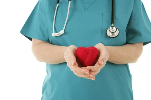 A nurse holding a heart shaped object illustrating self care
