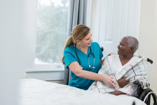 A  travel nurse communicating with a elderly patient